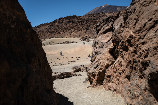Teide, Spain, April 5, 2023: Tourist hiking outsdoors on April 5, 2023 in Teide National Park, Tenerife, Canary Islands, Spain. Tourists hiking i the desert landscapes of the Teide National Park during a sunny summer day
