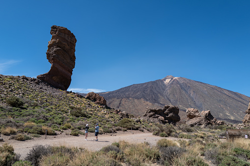 Teide, Spain, April 5, 2023: Tourist hiking outsdoors on April 5, 2023 in Teide National Park, Tenerife, Canary Islands, Spain. Tourists hiking i the desert landscapes of the Teide National Park during a sunny summer day