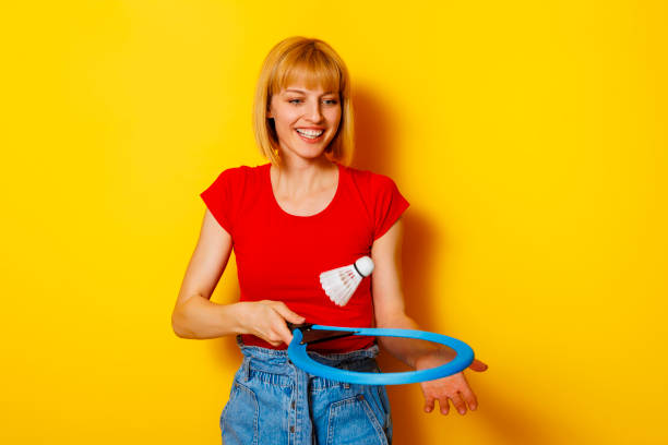 istock Woman playing badminton on yellow background 1489065983