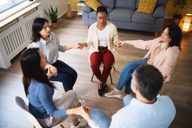 istock Multiracial people, in the circle holding hands, during group therapy 1489067164