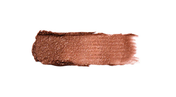 Wet bronzer, eye shadow smear isolated on white background. Wet bronzer, eye shadow smear isolated on white background. Bronze glittering eye shadow color swatch. bronze glitter stock pictures, royalty-free photos & images
