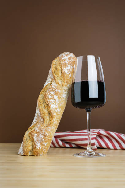 istock Minimalistic composition with a glass of red wine and a baguette. 1489070299