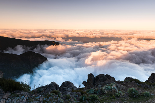 Madeira mountains landscape with peaks above clouds at sunset.