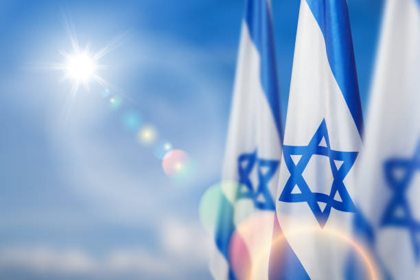 Israel flags with a star of David over cloudy sky background. Banner with place for text. stock photo