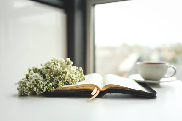 istock Open bible with flowers and a cup of tea on a white background 1489080713