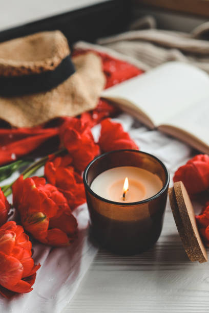 istock Cozy spring composition, burning candle, peonies and hat 1489082740
