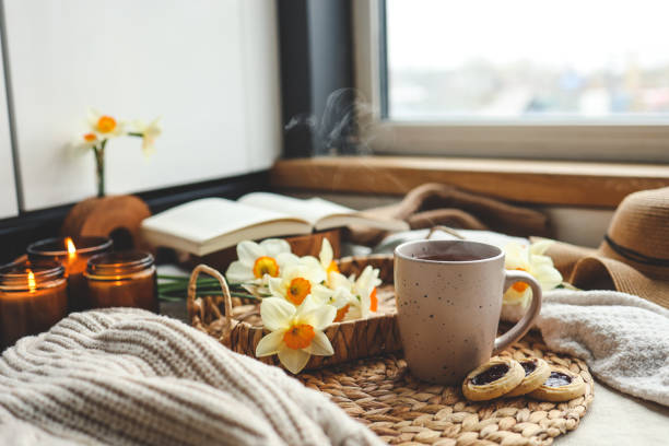 istock Spring still life, cup of tea, candles, open book and hat 1489084259
