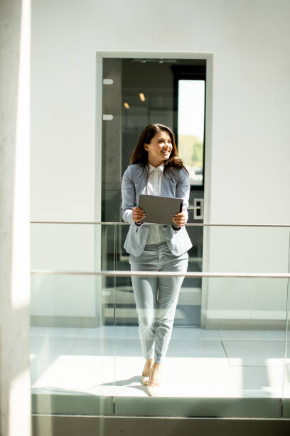 istock Young woman working on digital tablet in the office hallway 1489084692