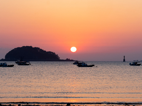 Young Man Fishing at the Beach at Sunset