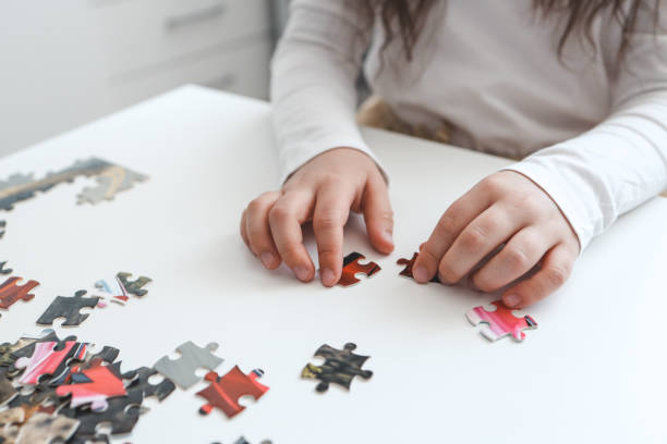istock Hands of a child doing a puzzle at table 1489085070