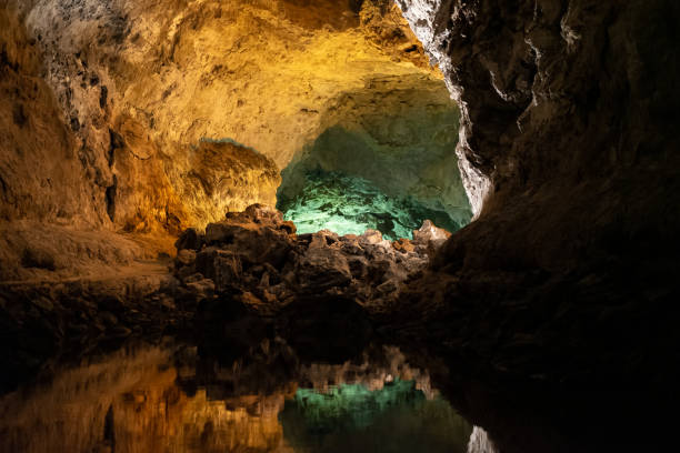 green cave (cueva de los verdes) in lanzarote, canary islands, spain. optical illusion - water reflection  an amazing lava tube and tourist attraction. - lanzarote canary islands volcano green imagens e fotografias de stock