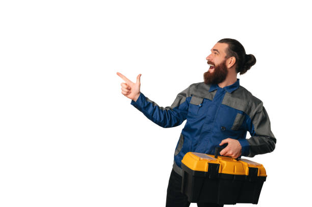 istock Ecstatic and surprised handy man holding a tool box is pointing aside. 1489088874