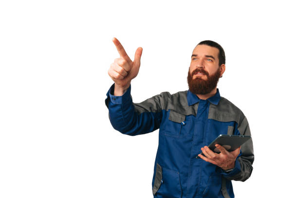 istock Young specialist in uniform is holding tablet and pointing on invisible screen. 1489088895