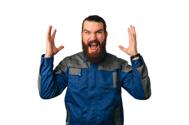 istock Nervous handy man wearing blue uniform screams and shows while gesturing. 1489088911