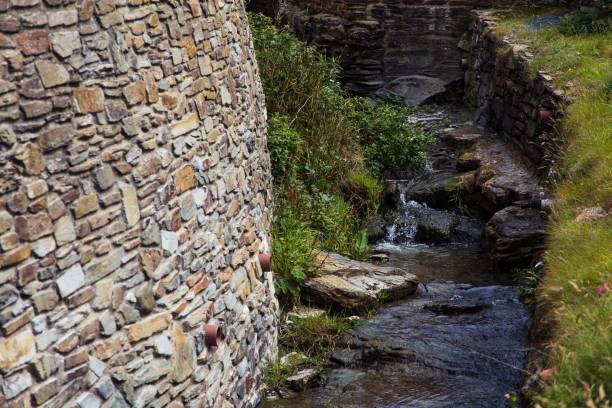 istock water flowing between two stone walls and grass at the edge 1489089063