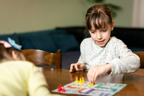 istock Two small girls playing board game at home during night 1489092439