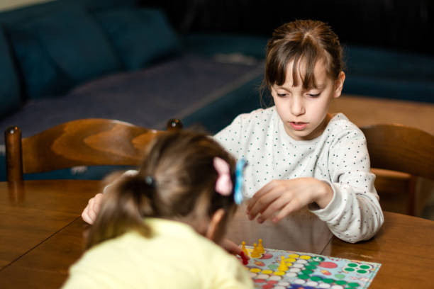istock Two small girls playing board game at home during night 1489092473