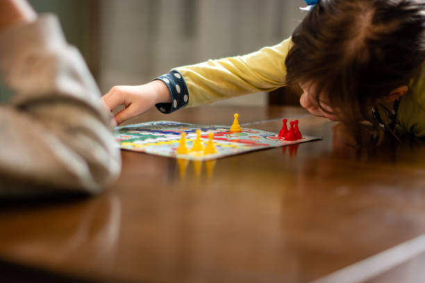 istock Two small girls playing board game at home during night 1489092579