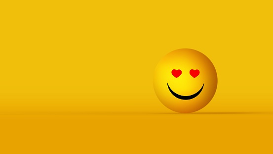 A cheerful emoji with heart eyes isolated on yellow background with copyspace