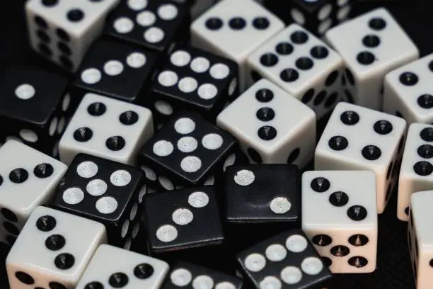 Photo of Close up of white and black dice isolated on a black background