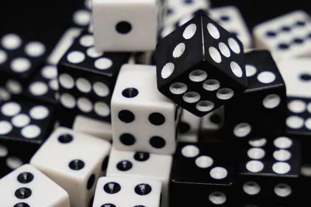 Photo of Close up of white and black dice isolated on a black background