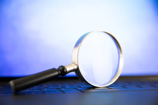 istock Magnifying Glass on Top of Computer Keyboard 1489094589