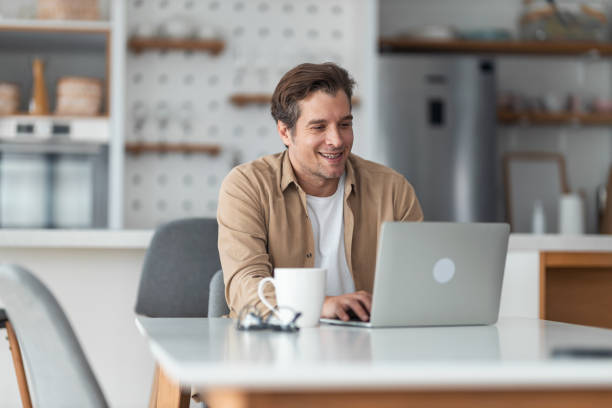 istock A smiling man doing some morning freelance work on his laptop and drinking coffee. 1489095202