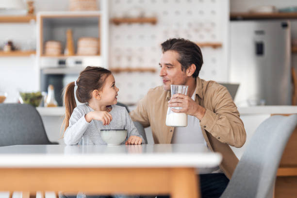 istock Smiling dad and daughter looking at each other, having a breakfast time at home. 1489096369