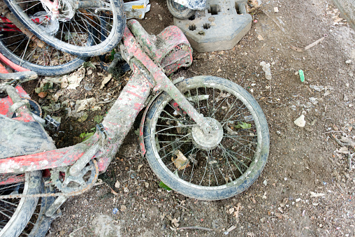 Moped with mud, fished up from the river Seine in Paris. in a heap with other bicycles and iron objects.