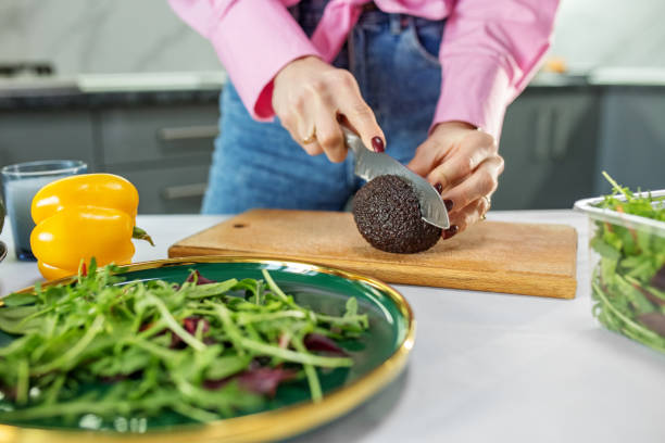 обрезанный вид женских рук, нарезающих свежий салат с овощами на кухонном столе. заживать - 13280 стоковые фото и изображения