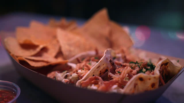 Close-Up Shot of Delicious Fish Street Tacos from a Fast Food Truck or Local Business Taco Shop in San Diego under Vibrant-Colored Christmas Lights