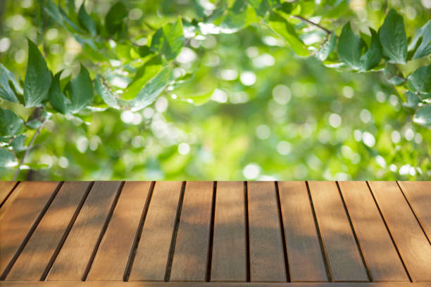 istock wooden table with forest bokeh background 1489097440
