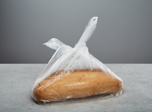 Whole bread in plastic bag on table