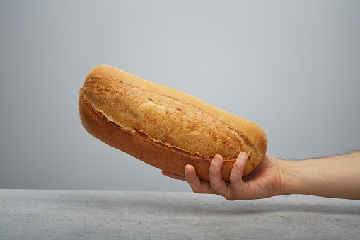 Happy brunette eating sandwich on white background