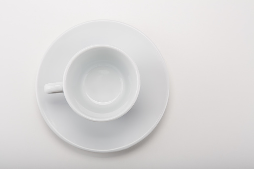 Empty white seramic espresso coffee cup with saucer on white background