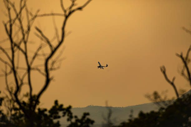 istock Small Plane Gliding Above Landscape at Sunset 1489105053