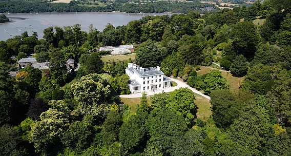 DRONE AERIAL VIEW: Greenway House overlooking the River Dart (in background). Greenway House and its gardens were formerly owned by the legendary literary figure and author, Agatha Christie.