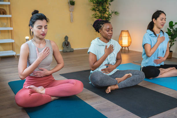 istock Multiracial women, meditating in lotus position, during group yoga class 1489107539