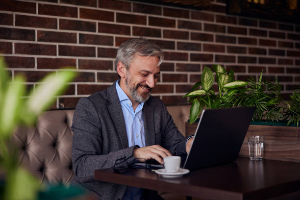 istock Ambitious senior man working online, over the laptop, drinking coffee. 1489109854