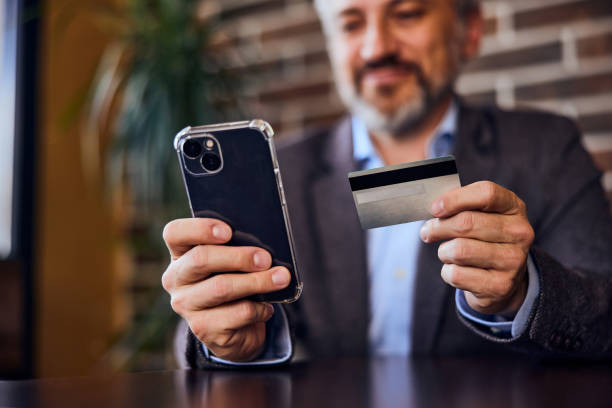 istock A senior businessman using his mobile phone and a card, paying something online. 1489111612