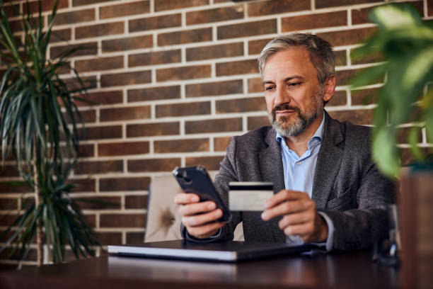 istock A businessman sitting by the work desk with a mobile phone and c 1489111644