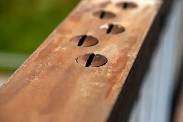 rusty screws on a bridge railing