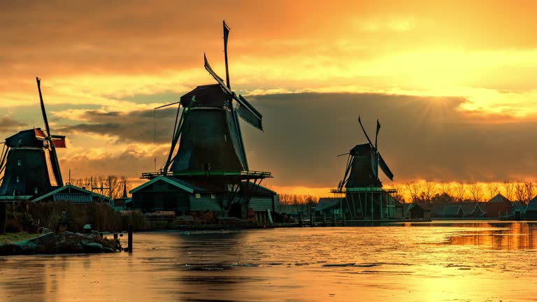 TIME LAPSE  Silhouette of traditional windmills at riverside