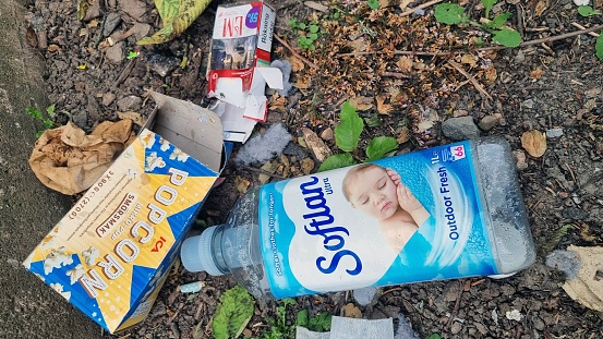 Falkoping, Sweden – March 10, 2023: A bottle of soap andets has been discarded in a patch of dirt