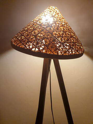 Floor lamp in the living room on a brown wooden floor and with a white wall in the background