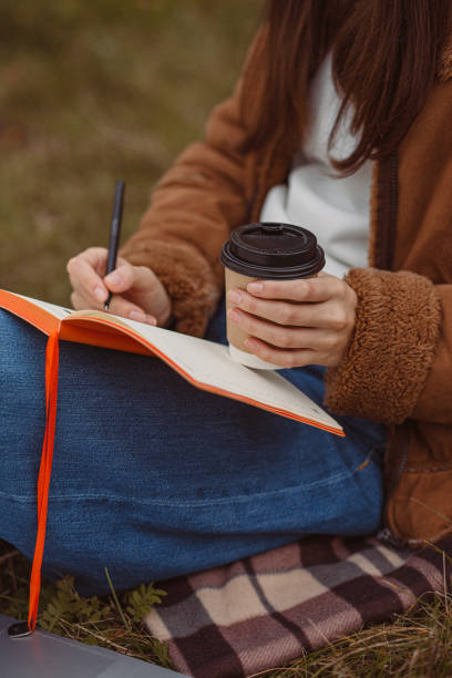 istock Female student with coffee writing in note pad in campus 1489123359