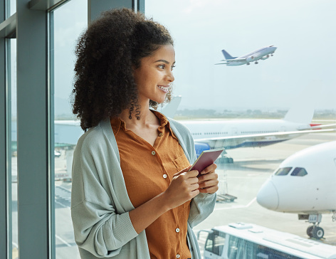 Passport, airport and woman waiting to board her flight for a business work trip in the city. Travel, professional and African female employee watching the planes before leaving for corporate meeting