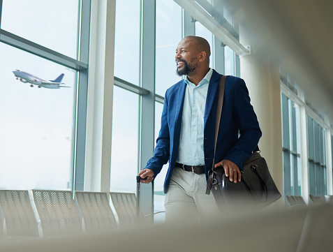 Black man, business and travel at airport on airplane for professional trip, journey or flight. Happy manager walking with suitcase, luggage and bag for boarding, check in or smile at terminal window