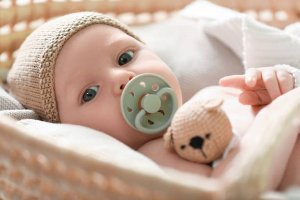 cute newborn baby on white blanket in wicker crib, closeup - baby stockfoto's en -beelden