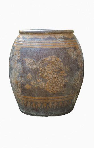 A brown water jar with a dragon pattern that has been used until it is old and corroded.It is the way of life of Thai people that can still be seen in the countryside. pottery jar on white background.